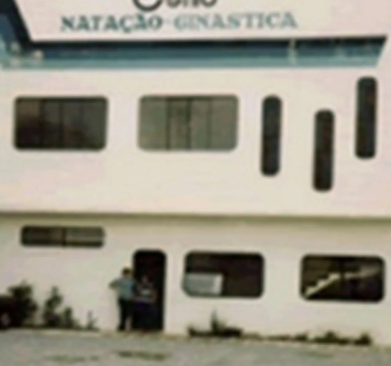 Foto antiga da fachada da Estilo, com a placa de natação e ginástica no alto do prédio
